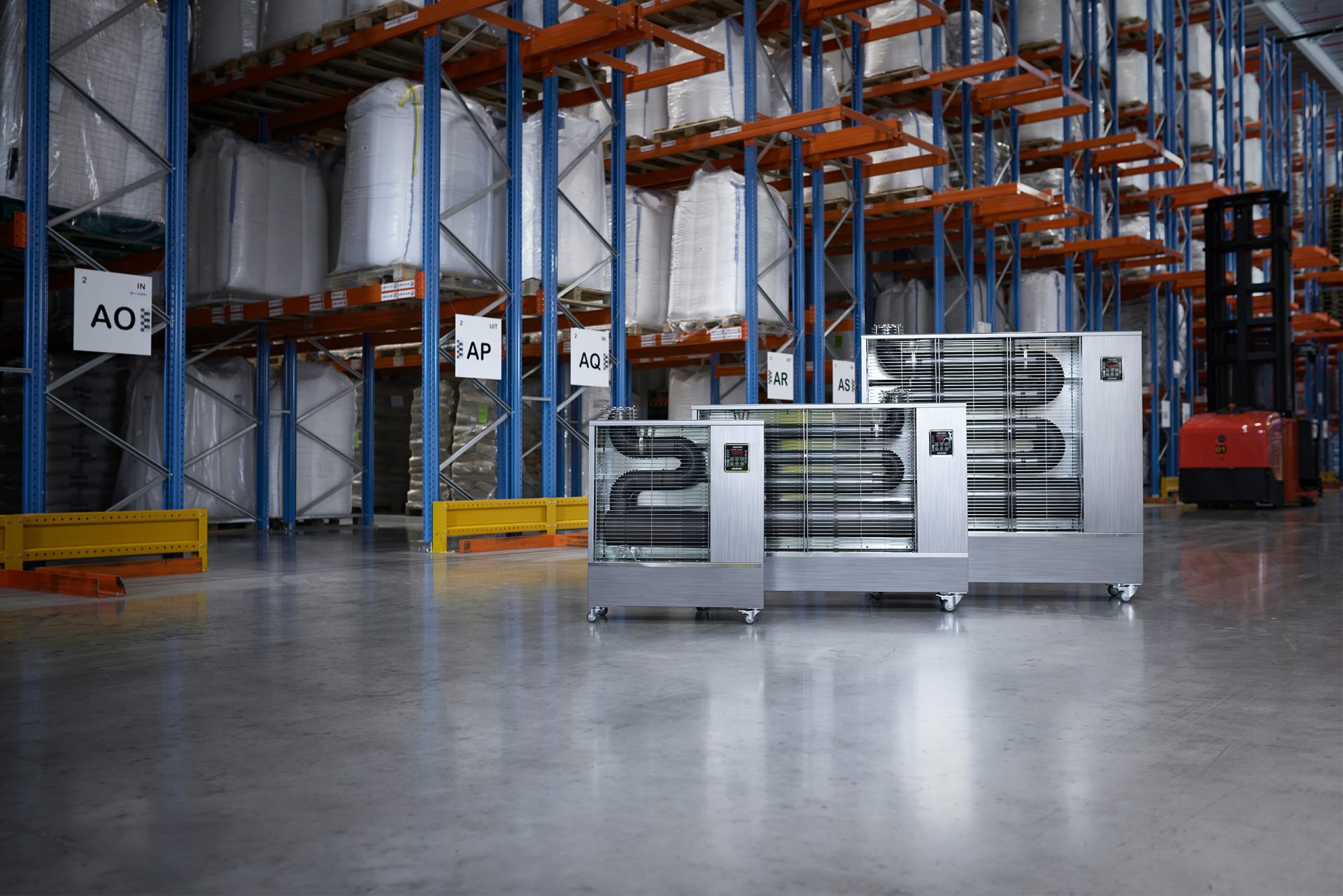 Full range of Toyotomi infrared heaters standing next to each other in a warehouse