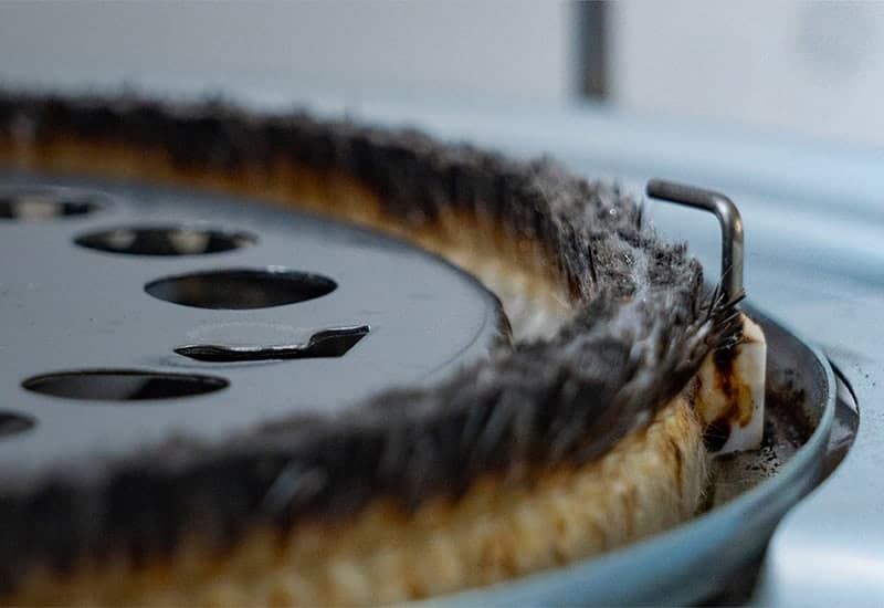 Close-up of a burnt-out heating element with damaged wiring.